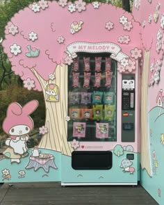 a pink and blue vending machine with hello kitty images on it's side