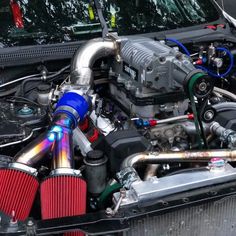 the engine compartment of a car with its hood up and exhaust pipes exposed to it