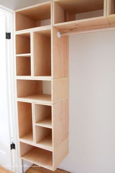 an empty closet with wooden shelves and white walls