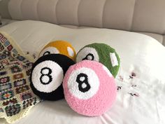 three balls with numbers on them are laying on a white bed sheet and next to a blanket