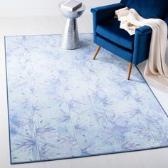 a blue chair sitting on top of a white floor next to a blue rug and table