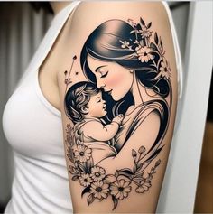 a woman holding a baby in her arms with flowers and butterflies on it's shoulder