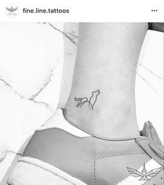 a small tattoo on the ankle of a woman's foot with a fox design