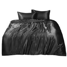 a bed with black sheets and pillows on it