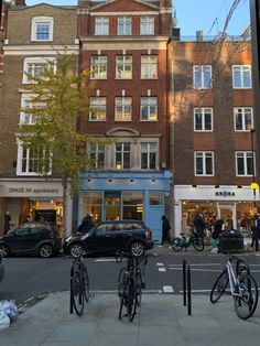 several bicycles are parked on the sidewalk in front of buildings