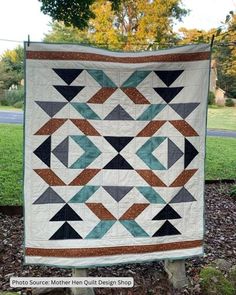 a quilt hanging from a tree in the grass