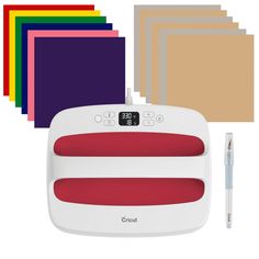 the cricut machine is next to several different colored sheets and a pen on top