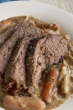 a white plate topped with meat covered in gravy