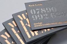 four business cards stacked on top of each other with gold foil lettering in the middle