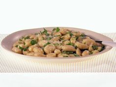 a white bowl filled with pasta and broccoli on top of a place mat