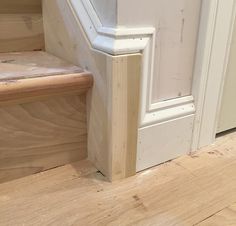 a cat is sitting on the floor next to some stairs and a door way that has been stripped off