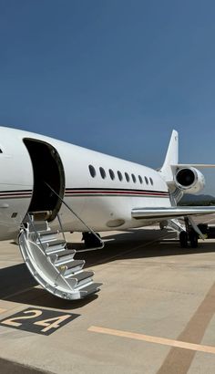 an airplane is parked on the tarmac with its door open and steps down to it