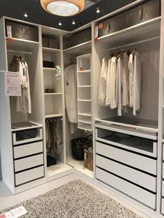 an empty walk - in closet with drawers and hanging clothes on the shelves, next to a carpeted floor