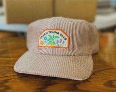 Celebrate your love for gardening with our Green Thumb Club Corduroy Cap! This stylish and comfortable hat is the perfect accessory for any green thumb. Whether you're tending to your garden or exploring the great outdoors, this cap will keep you looking and feeling your best. Features: Soft and Comfortable: Crafted from high-quality corduroy for a soft, comfortable feel. Embroidered Green Thumb Club Patch: Show off your passion for gardening with this eye-catching design. Adjustable Fit: The ad Corduroy Cap, Corduroy Hat, Gardening Hat, The Greenhouse, Cute Hats, Etsy Fashion, Green Thumb, Iron On Patches, Cotton Style