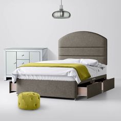 a bedroom with a bed, dresser and footboard in grey fabric on the floor