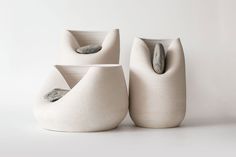 three white vases sitting next to each other