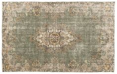 an antique rug with green and beige colors