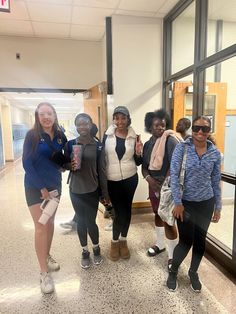 four women are standing together in the hallway