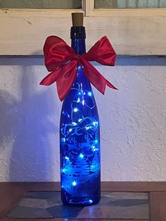 a lighted bottle with a red bow on it