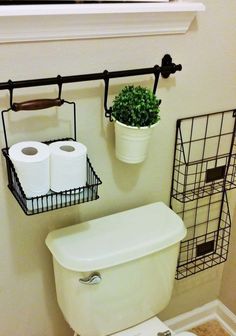 a white toilet sitting in a bathroom next to a metal rack with two rolls of toilet paper