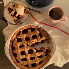 there is a pie on the table next to a cup of coffee