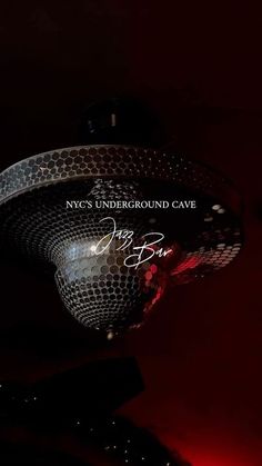 a shiny disco ball with the words nyc underground cave written on it in red light