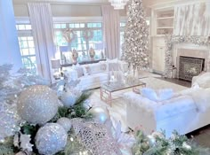 the living room is decorated for christmas with white furniture and silver ornaments on the fireplace mantel