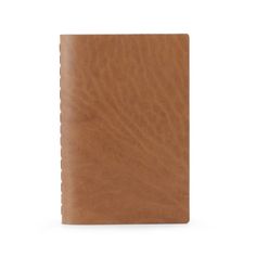 a brown leather notebook on a white background with clippings to the front cover