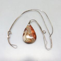 This lovely pendant necklace dates to the 1960 70s and was purchased from the stock of a local Lapidarist who was cleaning out his basement. The sterling setting is in MINT , never worn condition. It measures 1 3/4 inches tall  including the bale) and 7/8ths inch wide,  It is suspended from a 24 inch sterling silver metal chain with a spring ring clasp. The stone is mostly gray with a lovely white and clear veins running thru it and some brown on the edges.  It is just lovely.   All pieces are m Unique Teardrop Necklace For Collectors, Collectible Teardrop Necklace With Large Pendant, Collectible Teardrop Pendant Necklace, Vintage Handmade Teardrop Pendant Necklace, Collectible Vintage Teardrop Necklace, Collectible Brown Pendant Necklace, Agate Large Pendant Necklace, Vintage Hand-strung Agate Necklace, Untreated Agate Pendant Jewelry