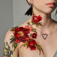 a woman with flowers on her chest has a heart tattooed on her chest and neck