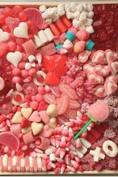 a box filled with lots of different types of candies and candy hearts on top of each other