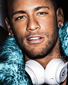 a close up of a person wearing headphones and a fur coat over their shoulders