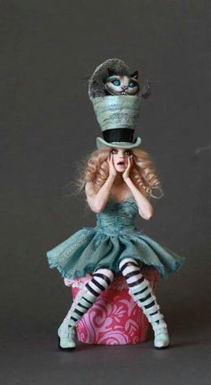 a doll is sitting on top of a ball with her hands to her face, wearing a green dress and striped tights