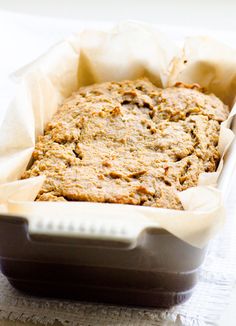 a loaf of oatmeal bread in a baking pan on top of a table