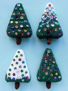 three crocheted christmas trees with colorful sequins on them, one is green and the other is white