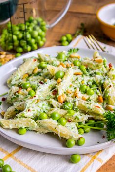 a white plate topped with pasta and peas