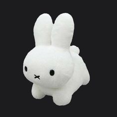 a white stuffed animal with black eyes on a black background in the shape of a rabbit