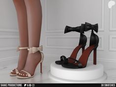 a pair of high heeled shoes with bows on the heels are standing next to each other