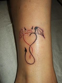 a woman's foot with a dragon and heart tattoo on the side of her leg