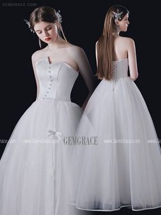 two women in white dresses standing next to each other with their backs turned towards the camera