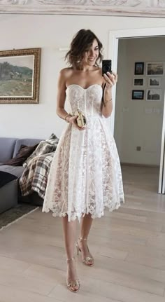 a woman in a white dress taking a selfie