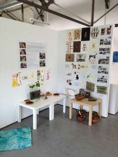 a room with two tables and several pictures on the wall behind them, all in different shapes and sizes