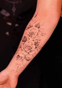 a woman's arm with a flower tattoo on the left side of her hand