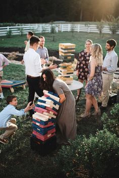 a group of people standing around each other with stacks of books on top of them