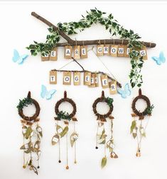 a group of wooden letters hanging from a wall next to wreaths and decorations with butterflies on them