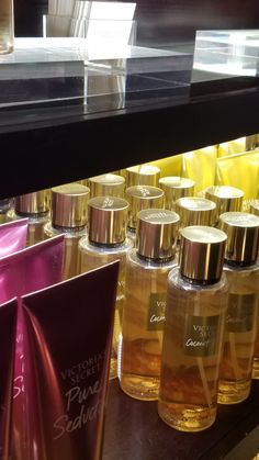 many bottles of perfume are lined up on the shelf