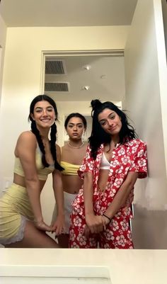 three women in bathing suits posing for the camera