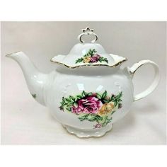 a white tea pot with flowers painted on it