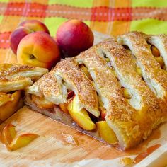 an apple pie is cut in half on a cutting board with some apples next to it