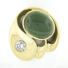 Here we have a beautiful modernist ring crafted in solid 18k yellow gold. This large ring features an oval cabochon cut tourmaline neatly bezel set in open work and displays a very fine and rich green color that brings a truly desirable look to this piece. The stone is wonderfully complemented by a round brilliant cut diamond that is burnish set and outstanding brilliant showing spectacular amount of sparkle that reflects its fine quality. This bold and well made ring has a nice high-polished fi Modernist Ring, Geometric Ring, Rich Green, Peridot Ring, Ring Crafts, Large Ring, Oval Cabochon, Round Brilliant Cut Diamond, Brilliant Cut Diamond